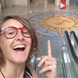 mujer sonriendo señalando un sol dibujado en el piso